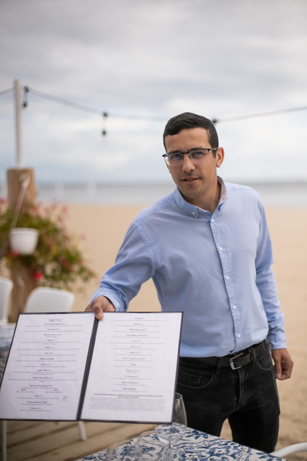 Andrzej Prokopiuk holding a menu