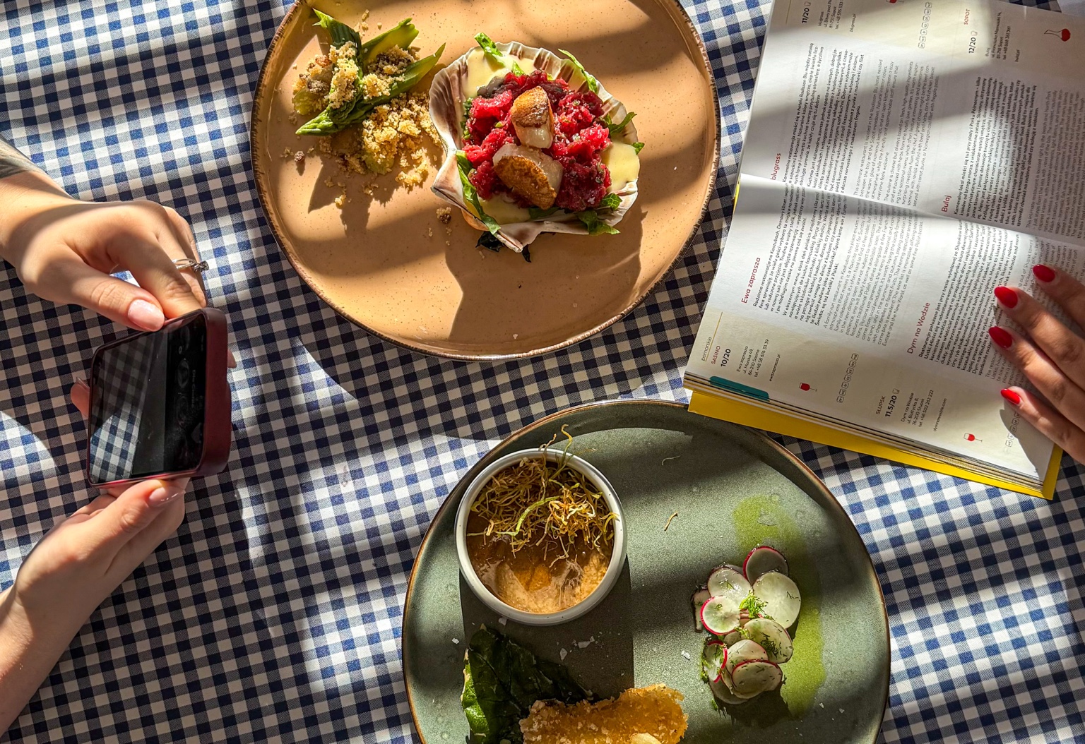 Dishes and an open Gault&Millau guide featuring Bulaj